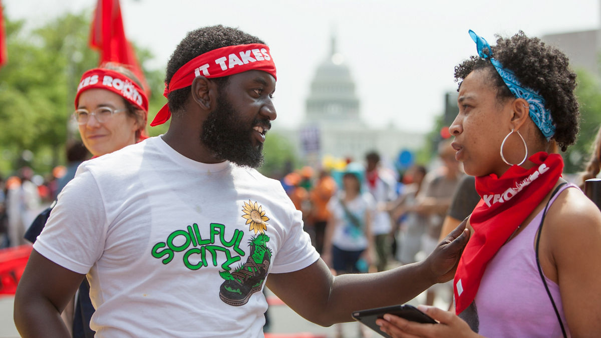 Multiracial activists gather on a city street to support a cause.